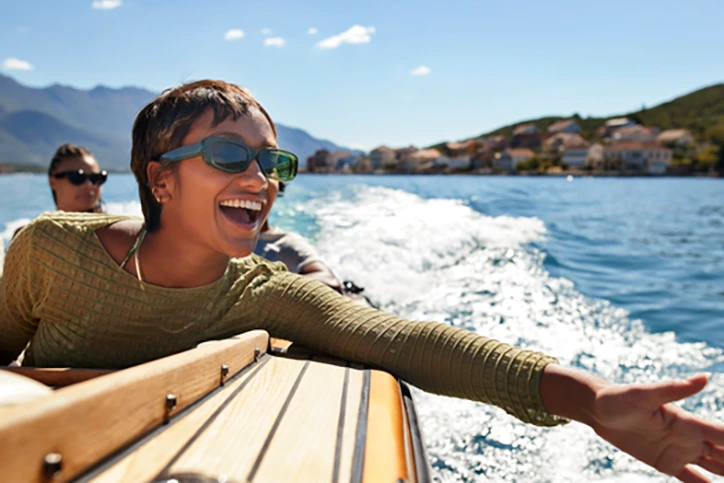 Cheerful young woman enjoying motorboat ride